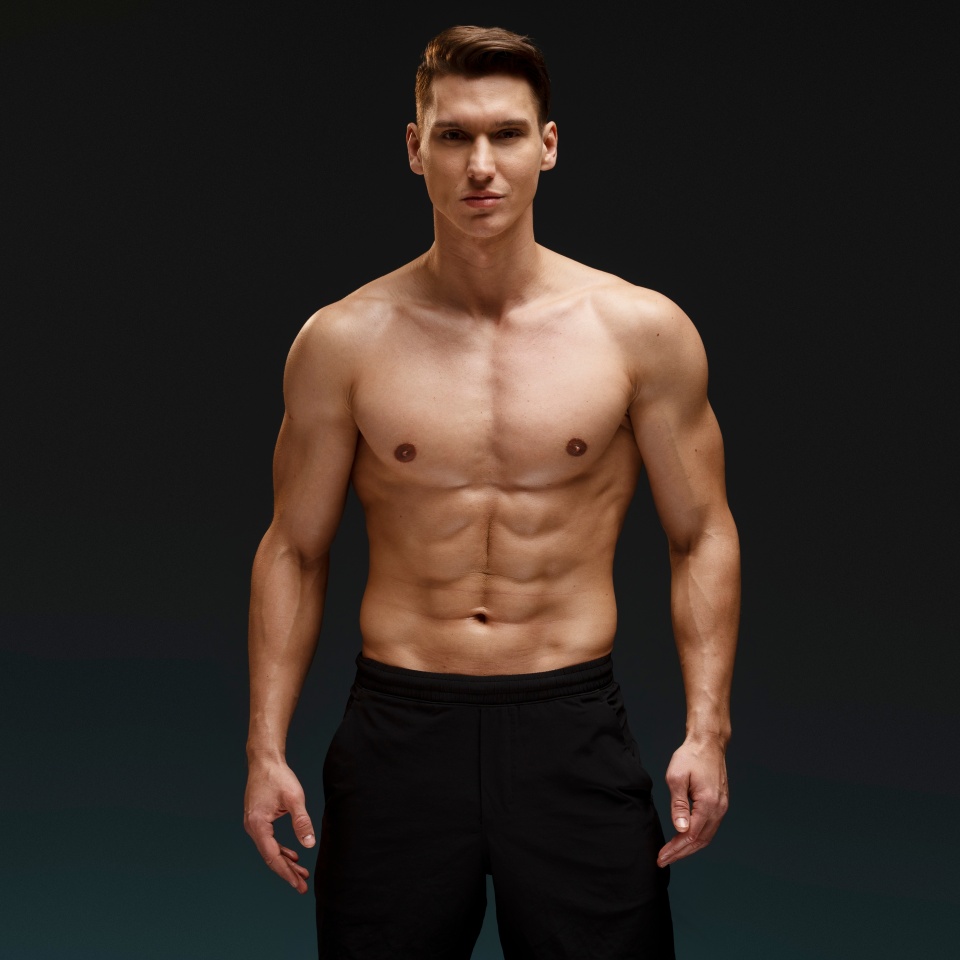 Caucasian nude torso sexy man posing at studio over dark wall background. Sport and figure concept