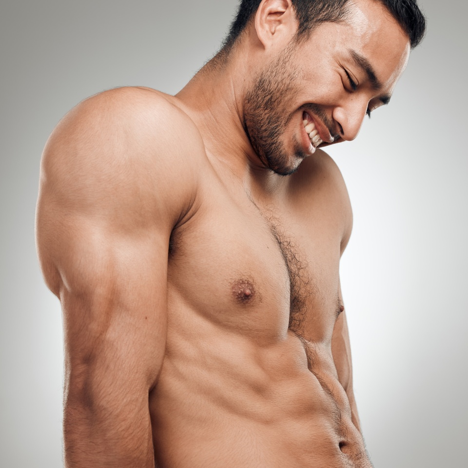 Man, thinking and confident in studio with abs or muscles, shirtless and grey background with model bodybuilder. Jeans, strong chest and Asian male person on backdrop, happy and six pack results