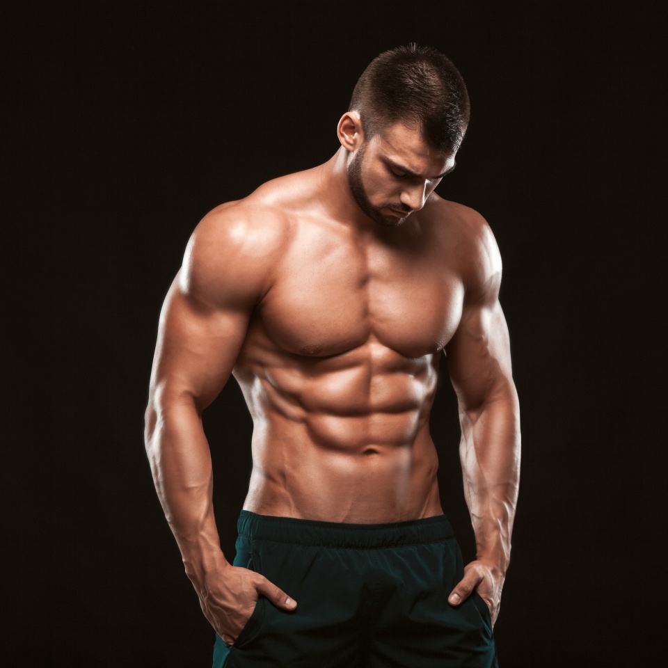 Strong Athletic Man - Fitness Model showing his perfect back isolated on black background with copyspace