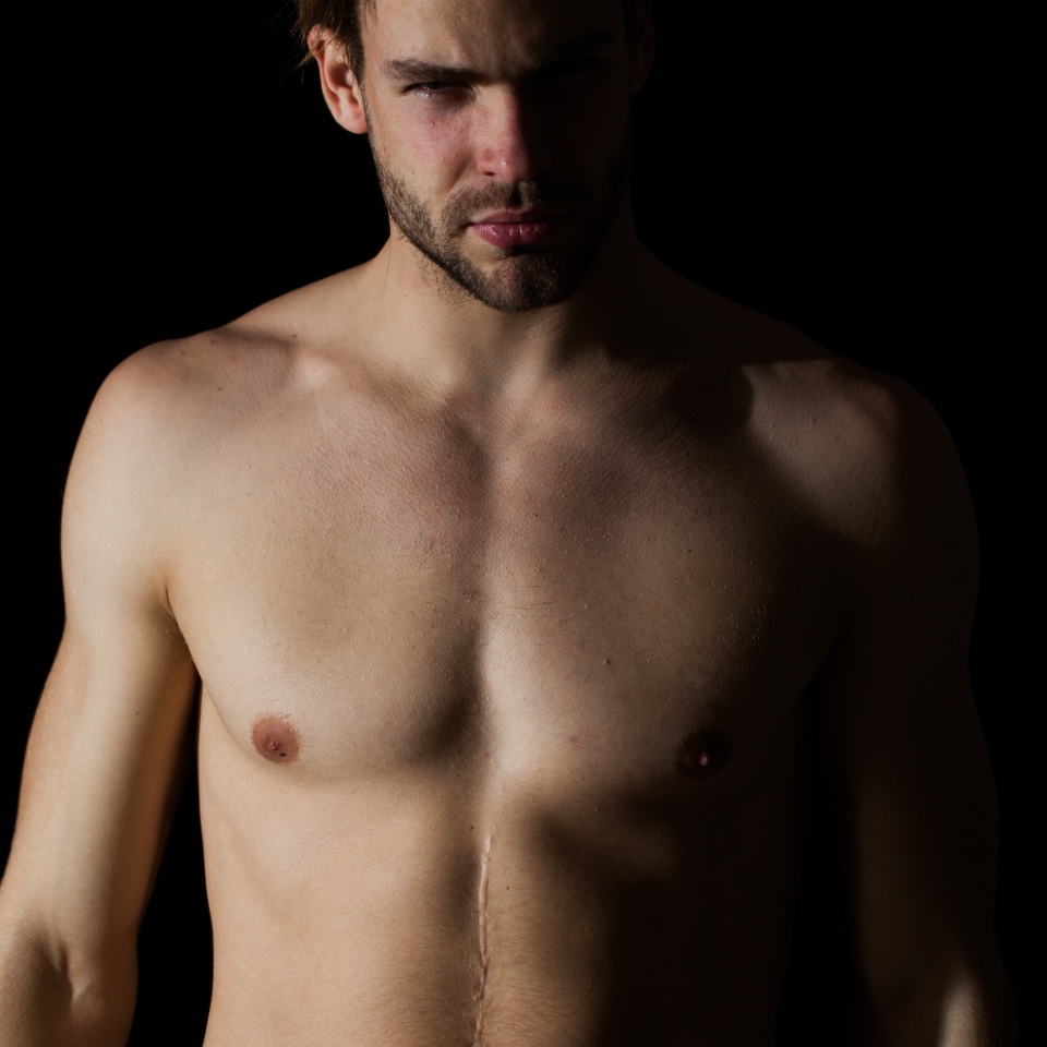 Fashion portrait of sexy male fitness model in underwear. Male swimwear & underwear concept. Muscular male model in trendy white underwear. Handsome sexy muscular naked man posing on a dark background