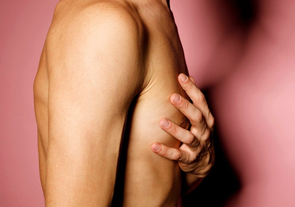 Close up man breast chest hold hand on his heart over pink background